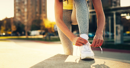 Naklejka premium Attractive sportswoman tying shoelace and getting ready for fitness