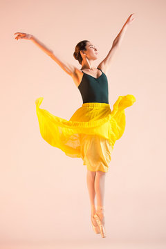 Young and incredibly beautiful ballerina is dancing at studio