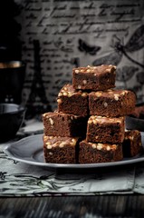 Brownie with pine nuts. Dark background. Rustic style