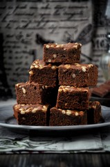 Brownie with pine nuts. Dark background. Rustic style