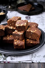 Brownie with pine nuts. Dark background. Rustic style