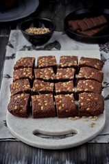 Brownie with pine nuts. Dark background. Rustic style