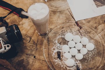 delicious meringue and cocoa and photo camera  on wooden table in cafe, top view.  winter christmas holidays, space for text