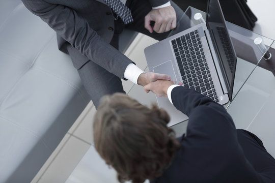 handshake of business partners above the Desk.