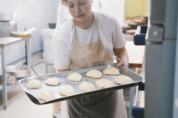 Cook puts pies into stove for baking