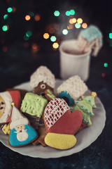 Christmas cookies and cup of tea on dark color bokeh lights background