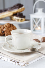 Cup of coffee and eclairs with chocolate