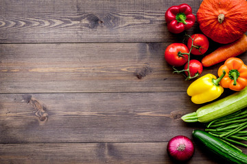 Base of healthy diet. Vegetables pumpkin, paprika, tomatoes, carrot, zucchini on dark wooden background top view copyspace