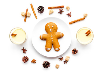 Eggnog for christmas evening. Two glasses near gignerbread cookie on white background top view