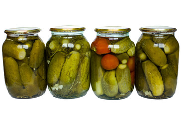 Pickled tomatoes and cucumbers in glass jars isolated on white background
