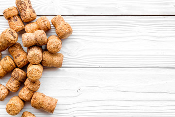 Heap of wine bottle corks on white wooden background top view copyspace