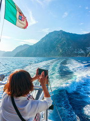 Asian tourist taking photos of Tyrrhenian sea and Positano tow