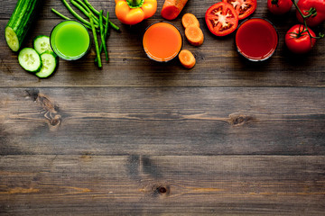 Fresh detox beverages with vegetables and fruits on dark wooden background top view copyspace