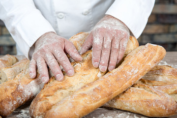 baker with traditional bread french baguettes