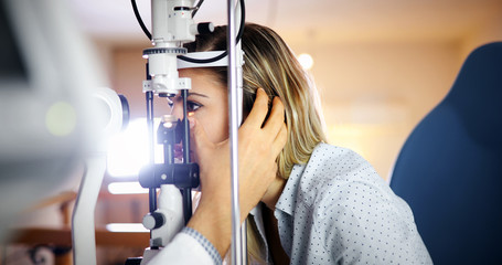 Optometrist examining patient in modern ophthalmology clinic - Powered by Adobe