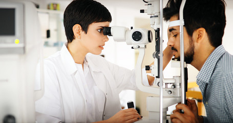 Fototapeta na wymiar Woman doing eye test with optometrist in eye sight clinic