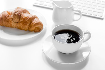 Businessman morning with keyboard, cup of coffee and croussant o