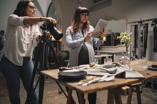 Pregnant Woman With A Colleague Working On A Food Photoshoot In A Studio