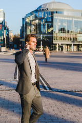 businessman with earphones walks in the city