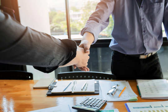Business people shaking hands finishing up a meeting. Two confident businessman shaking hands during a meeting in the office, success, dealing, greeting and partner concept.