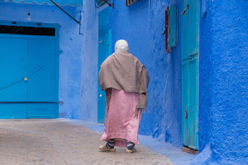 Traditional moroccan courtyard in Chefchaouen blue city medina in Morocco, architectural details in Blue town Chaouen. Typical blue walls and colorful flower pots.