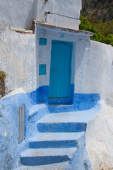 Traditional moroccan courtyard in Chefchaouen blue city medina in Morocco, architectural details in Blue town Chaouen. Typical blue walls and colorful flower pots.
