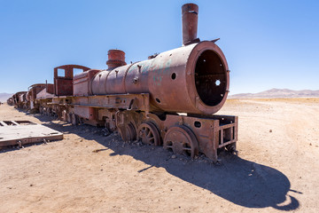 Fototapeta na wymiar Train rusty locomotive carcass railrway carriages, Bolivia trains cemetery.