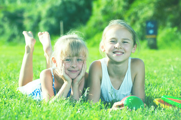 Fototapeta premium Two happy girls laying on grass