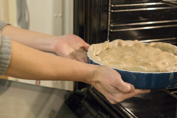 Girl puts the cake in the oven