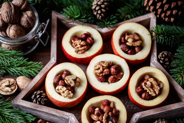 Baked apples with cinnamon on rustic background. Autumn or winter dessert. Closeup photo of a tasty baked apples with christmas decoration