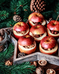 Baked apples with cinnamon on rustic background. Autumn or winter dessert. Closeup photo of a tasty...