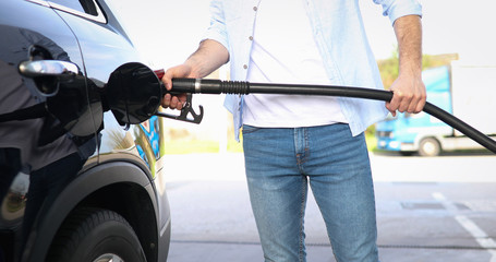Hand refilling the car with fuel