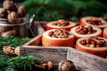 Baked apples with cinnamon on rustic background. Autumn or winter dessert. Closeup photo of a tasty baked apples with christmas decoration