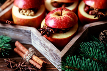Baked apples with cinnamon on rustic background. Autumn or winter dessert. Closeup photo of a tasty baked apples with christmas decoration