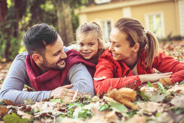 Family time . Parents poses with daughter.