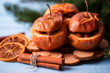 Baked apples with cinnamon on rustic background. Autumn or winter dessert. Closeup photo of a tasty baked apples with christmas decoration