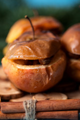 Baked apples with cinnamon on rustic background. Autumn or winter dessert. Closeup photo of a tasty baked apples with christmas decoration