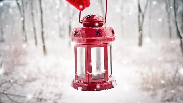 Holding in red glove red candle lantern in the winter forest. Snow forest snowfall. Christmas Winter New Year background trembling flame Scenery. Fairy magic forest flashlight. Seamless loop, concept,