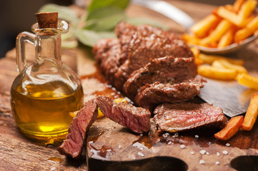 Grilled medium rare beef steack served on wooden rustic board