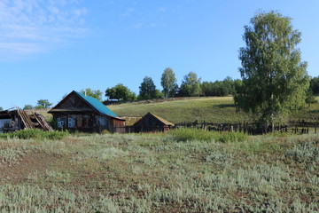 Very old wooden house in the remote Russian village in the summer against a blue sky