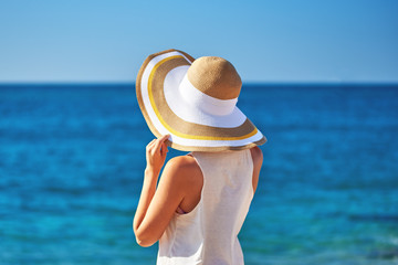 Woman in beach hat looking at the sea. - 183663949