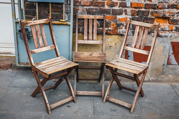 many empty wooden chairs outside the restaurant