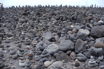 Balanced stone pyramid on sea shore, waves in background