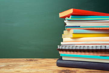 Classroom with blackboard, wooden table and books