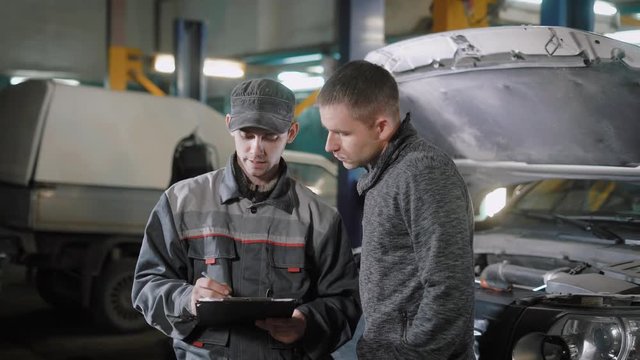 Client signs documents in a auto repair shop.