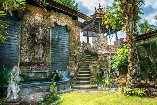 waterfalls and figures of stone in a traditional garden balinese. indonesia. bali. ubud