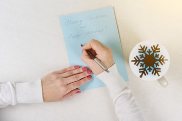 Christmas letter - congratulations. Cup with hot tea and a symbolic snowflake