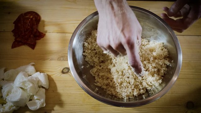 Cooking food. Close-up shot of male hands stirring butter and grated cheese. 4K
