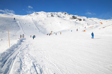 Fototapeta na wymiar People skiing on prepared slopes covered by fresh snow in Tyrolian Alps, Zillertal, Austria, Europe