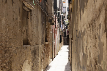 Fototapeta na wymiar View of a narrow street with old, historical buildings in Venice